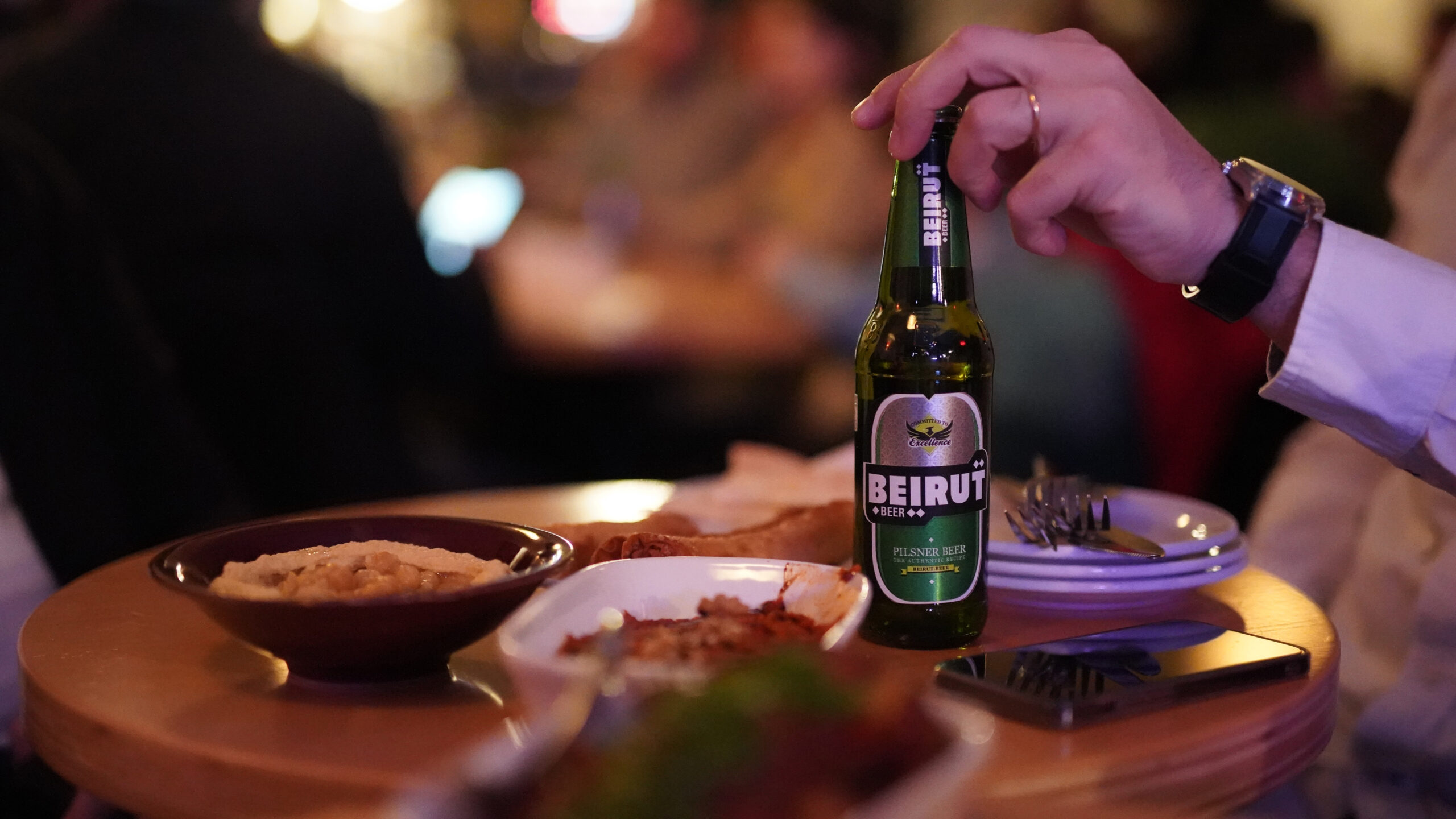 Un homme tient une bouteille de bière "Beirut"