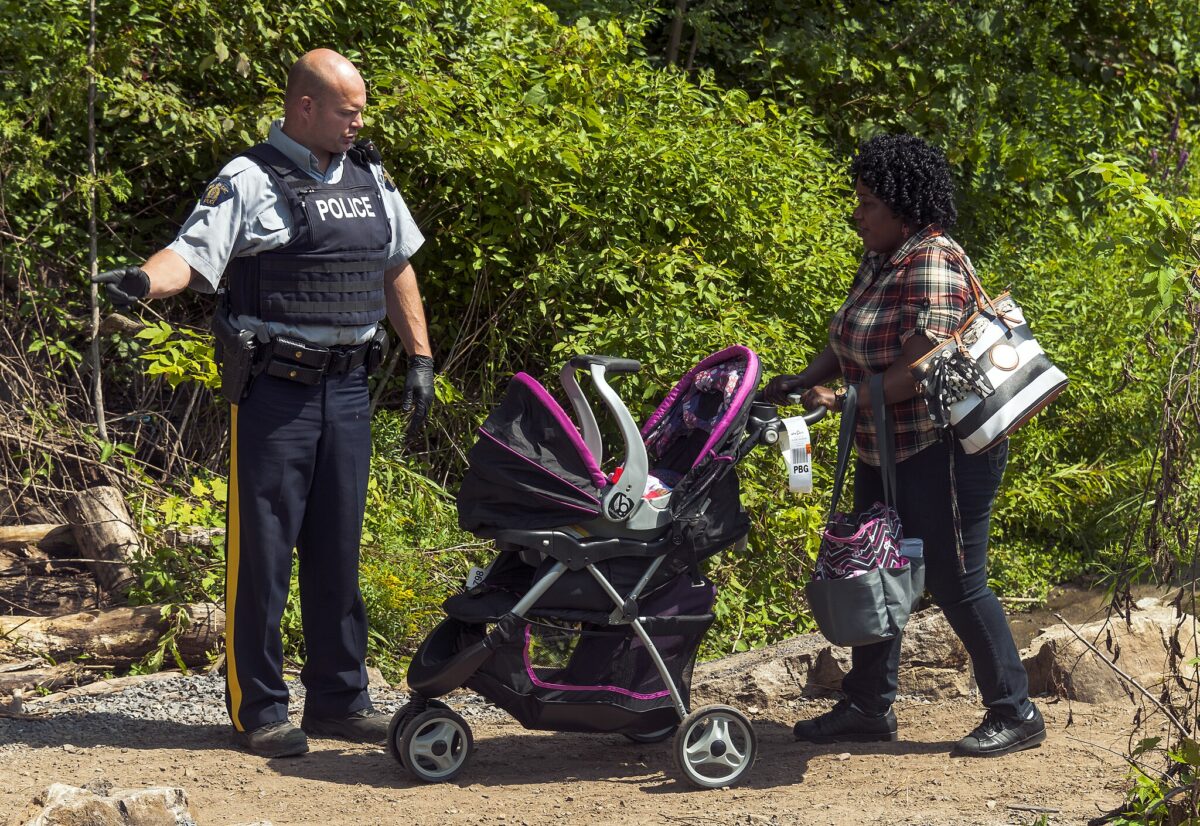 Une femme avec une poussette entre au Canada par le Chemin Roxham. Photo: Daniel Case